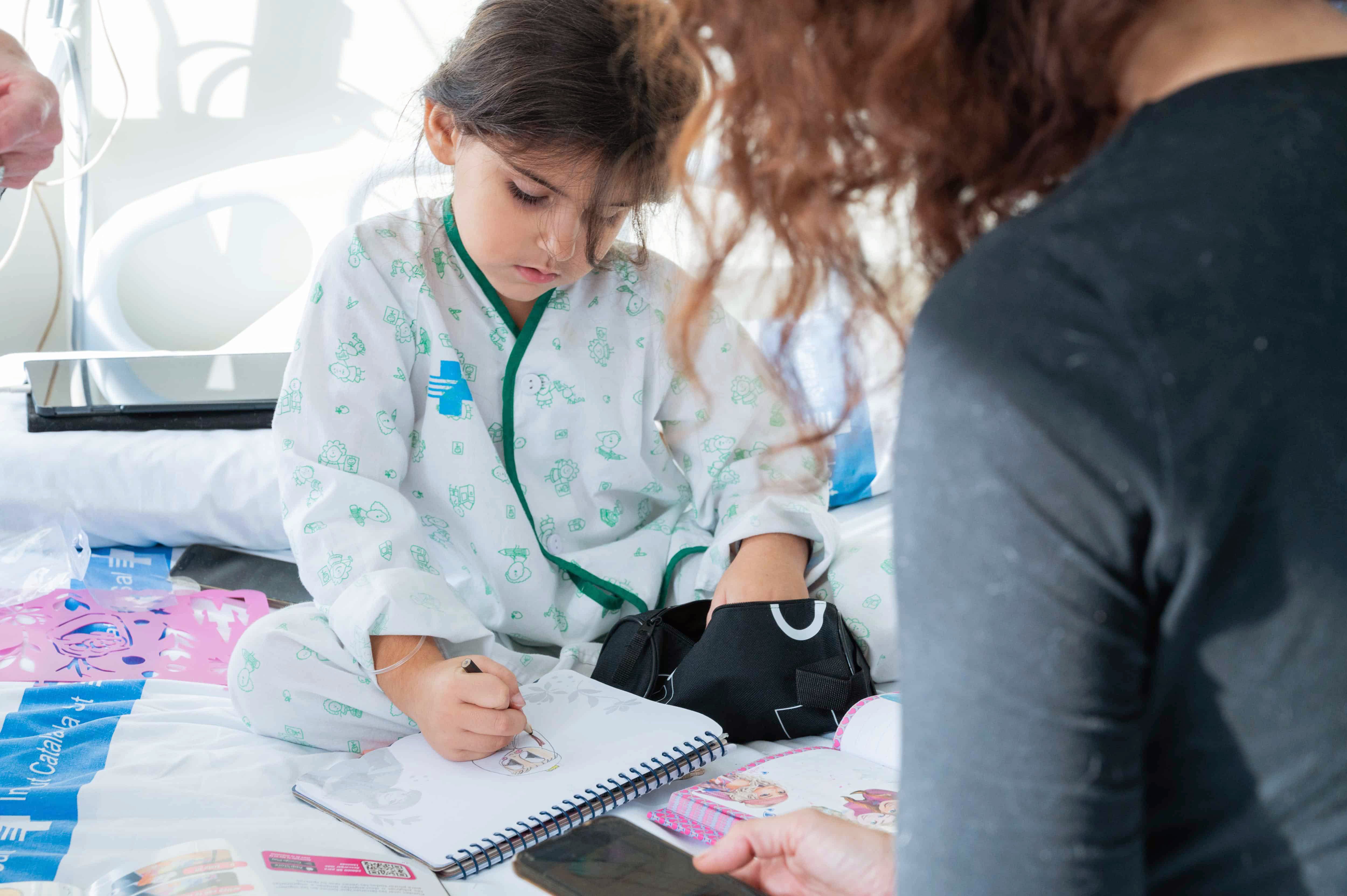 Infant dibuixant al llit