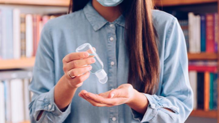 Dona posant-se gel hidroalcohòlic